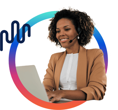 Woman smiling while looking at a computer and wearing a headset. Woman smiling while looking at a computer and wearing a headset.